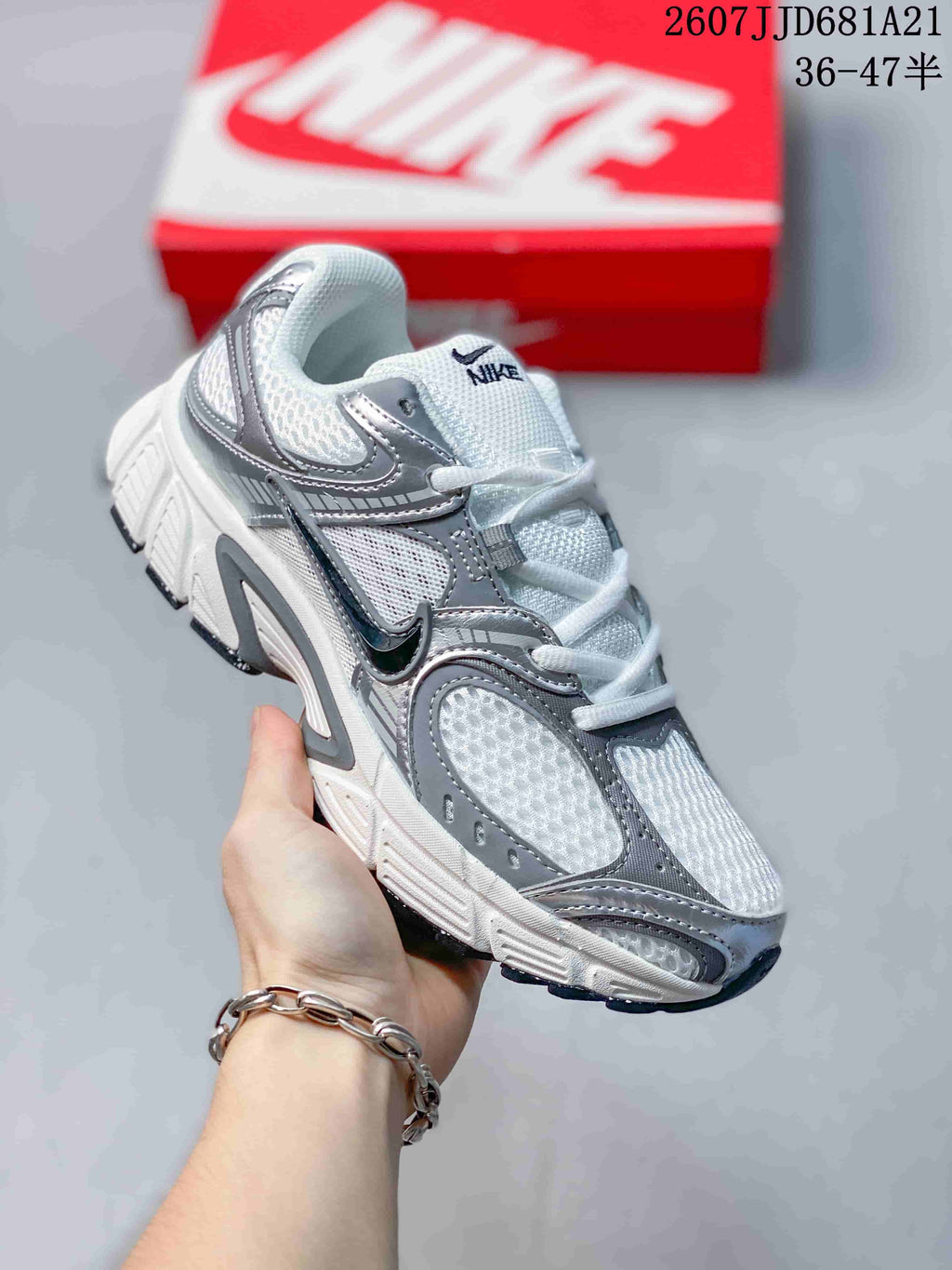 Angled side view of a white and grey Nike V5 RNR sneaker showing the lace-up upper, Swoosh branding, and chunky sole.