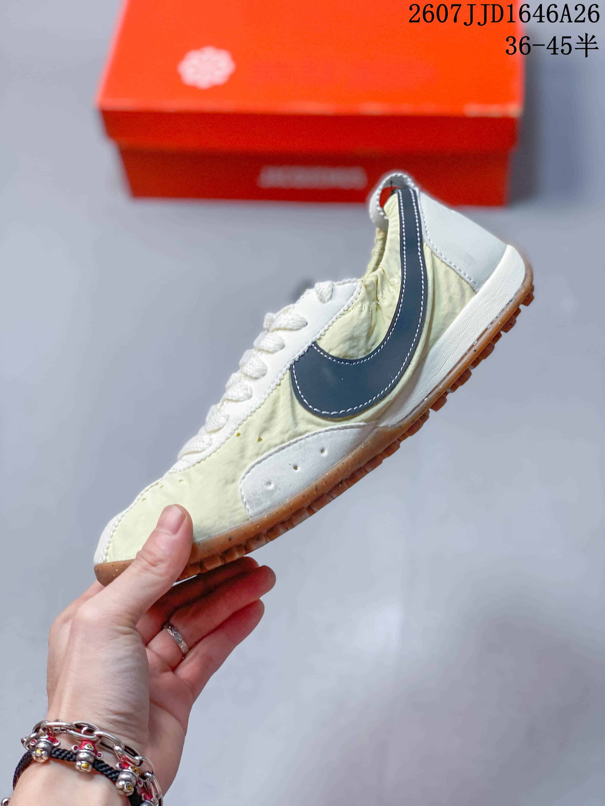 Side profile highlighting the dark navy Swoosh, cream upper, white overlays, and gum outsole.