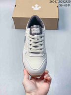 Top view of a cream Descente sneaker showing its laces, tongue label, and panel details.