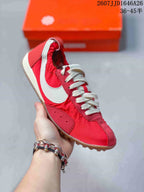 Angled side view of the red and white sneaker showing the white Swoosh, cream laces, and gum-colored outsole.