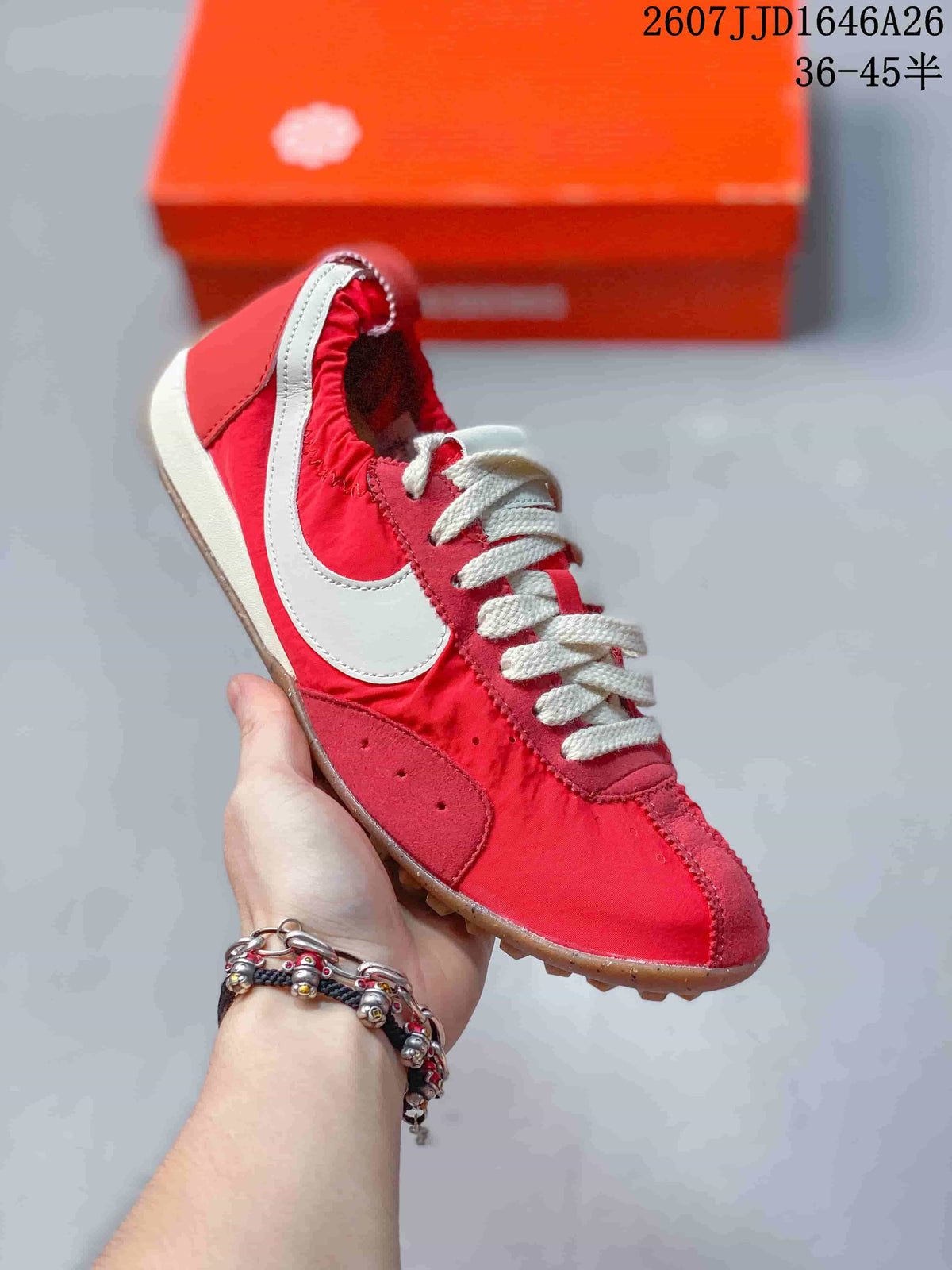 Angled side view of the red and white sneaker showing the white Swoosh, cream laces, and gum-colored outsole.