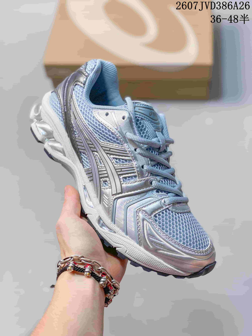 Three-quarter side view showing the silver and light blue mesh upper and layered sneaker construction.