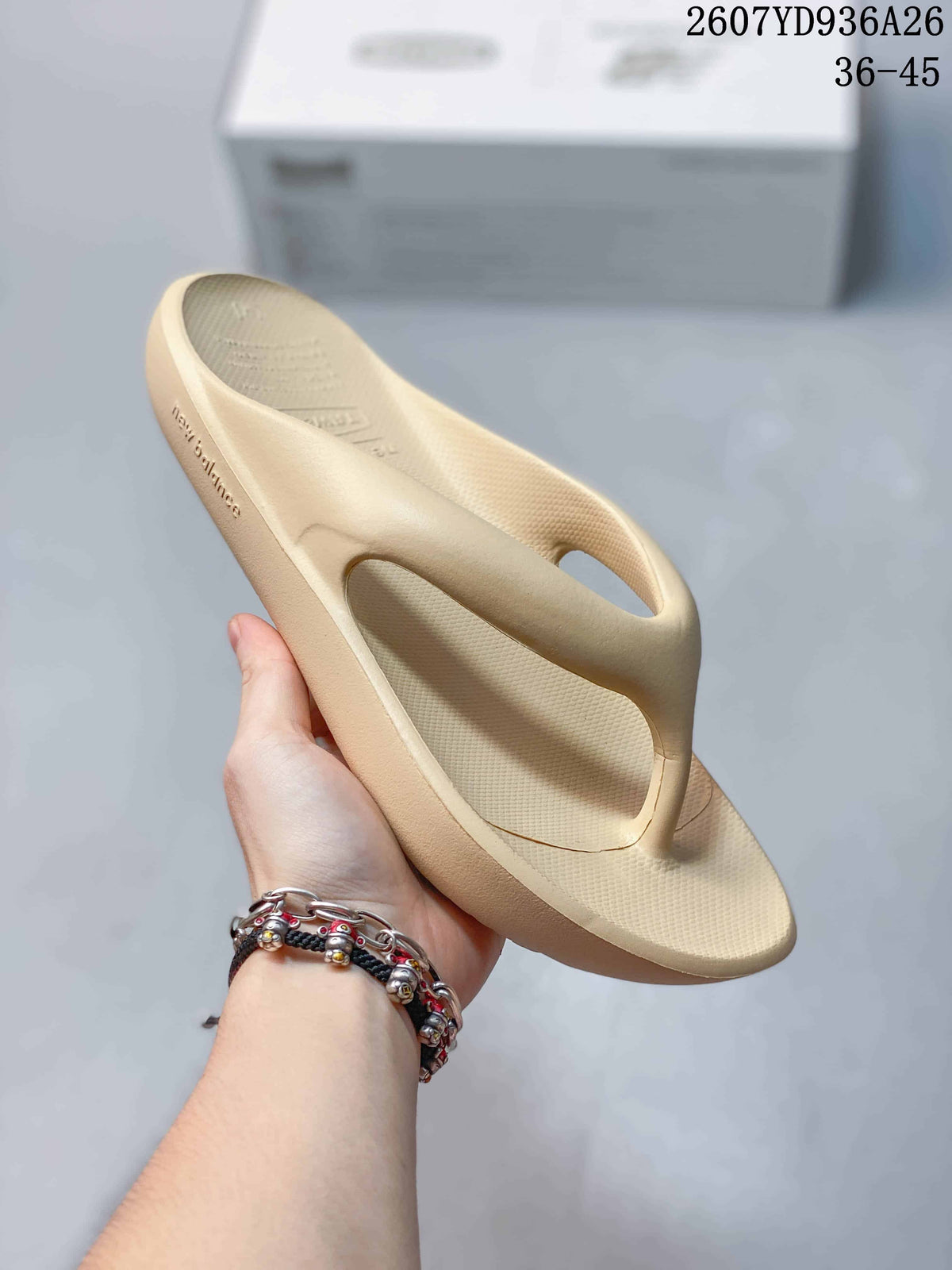 Angled side view of the beige thong sandal showing the footbed, toe-post strap and sole profile.