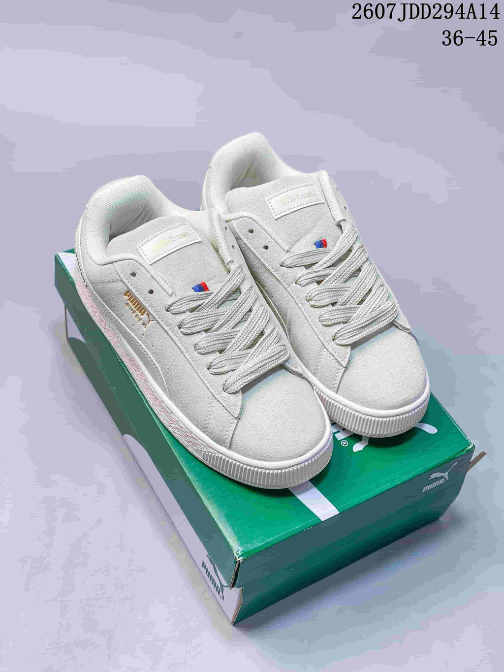 Pair of white PUMA Suede XL sneakers displayed on a green shoebox, with the style code and EU size range visible at the top.