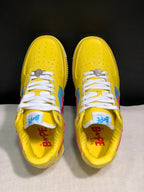 Top-down view of the yellow sneakers showing perforated toe boxes, white laces, metallic lace hardware, and branded insoles.