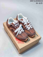 Green and brown sneakers shown together on branded boxes, highlighting the contrasting colorways and layered upper design.