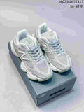 Pair of New Balance 9060 sneakers in pale mint green, white and gray, displayed on a shoebox.