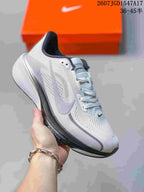 Angled side view of a white, gray, and black Nike Pegasus 42 running shoe with its lace-up design, layered sole, and side swoosh visible.