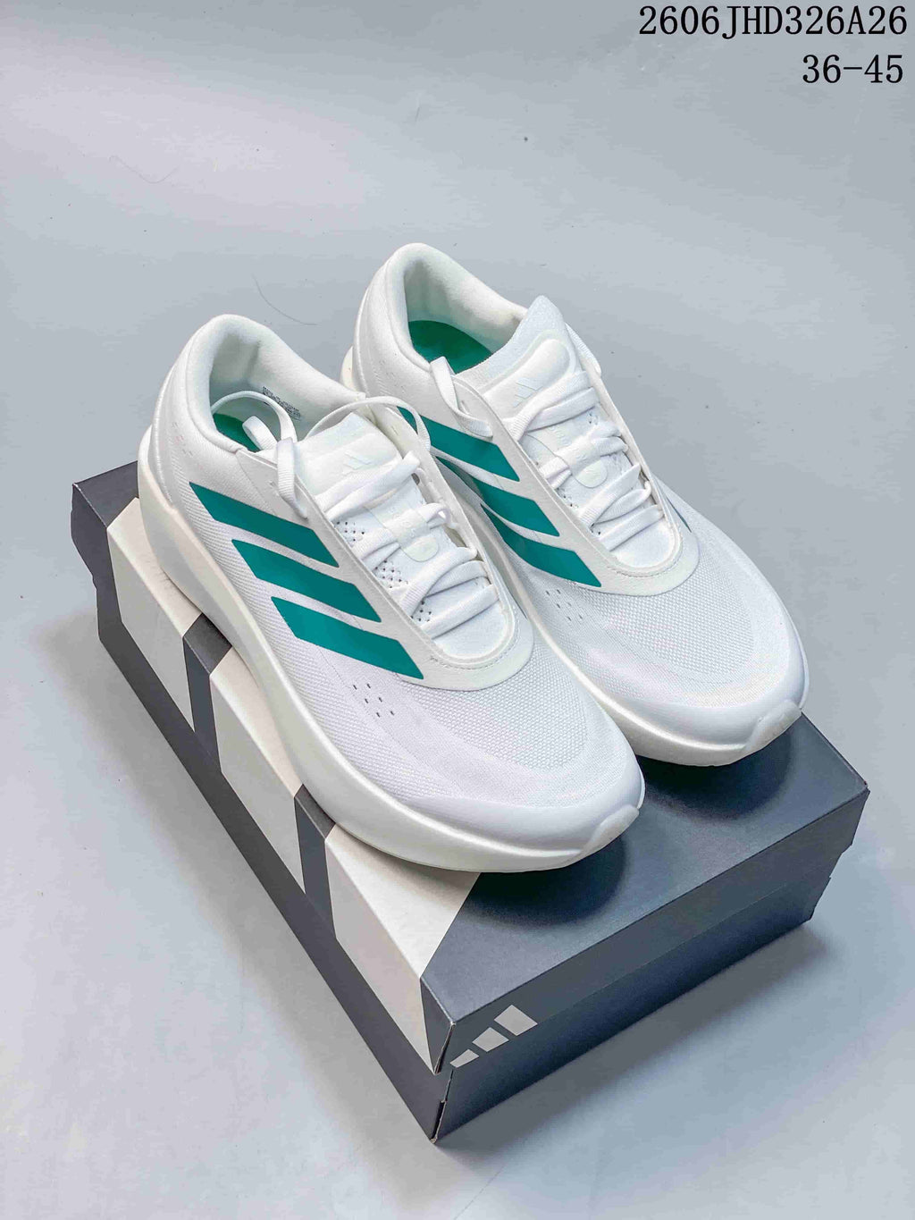 White adidas Supernova Rise 3 shoes with teal stripes, shown on a shoebox