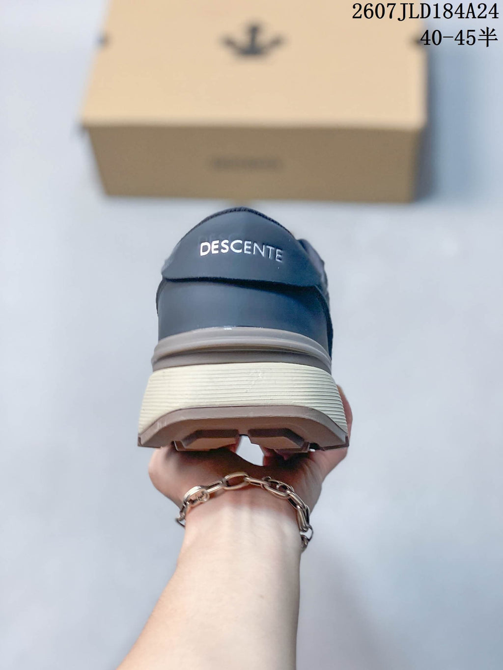 Rear view of the navy sneaker showing DESCENTE branding, layered heel construction and textured outsole.