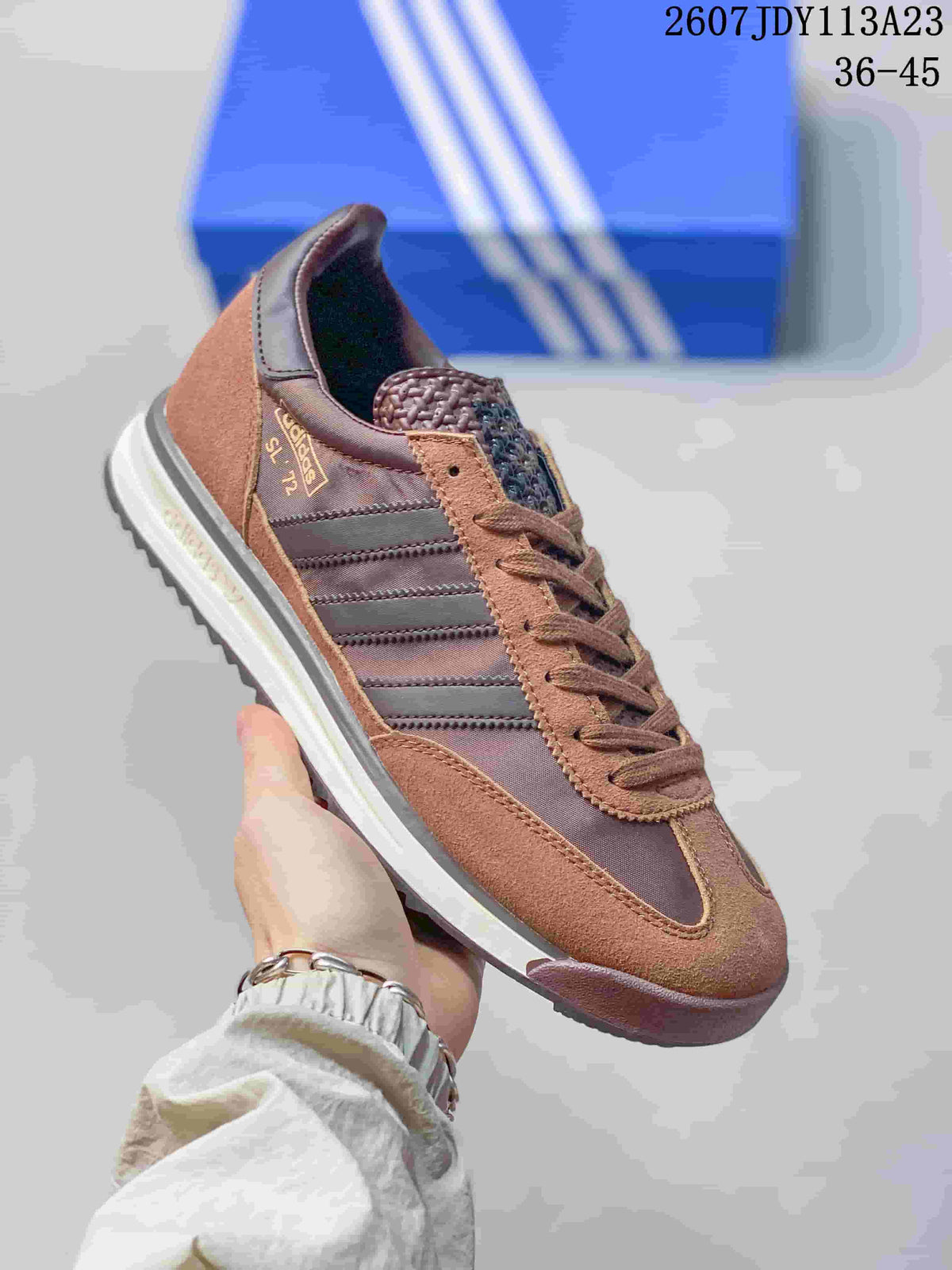 Angled side view of the brown adidas SL 72 sneaker showing the heel label, three stripes, layered sole, and style code text above.