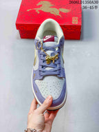 Front view of the Nike SB Dunk Low showing the perforated toe, lavender overlays, and dangling gold-tone charm.