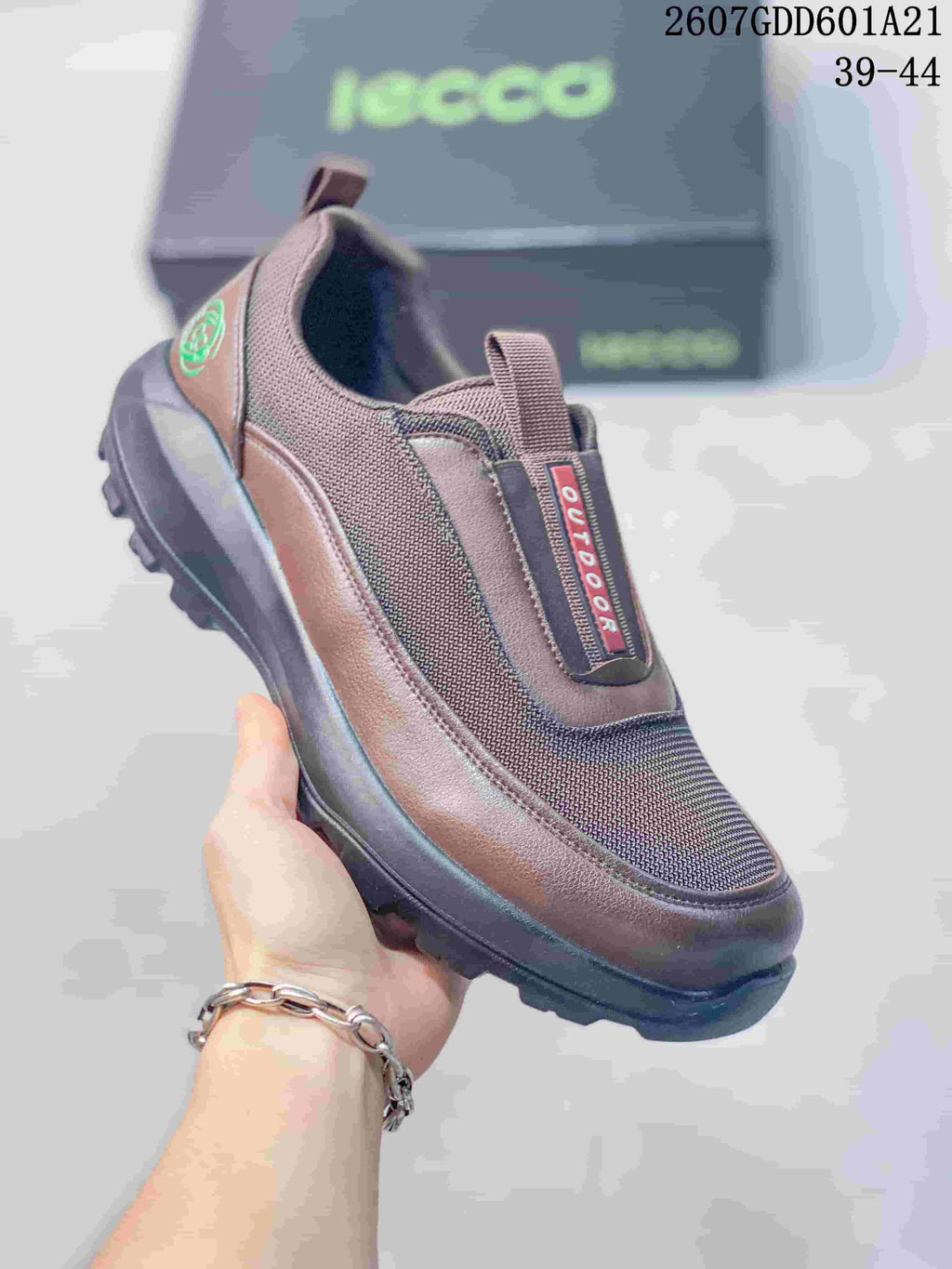 Angled front view of the brown ECCO slip-on shoe showing the textile upper, brown trim, heel pull tab, and black outsole.