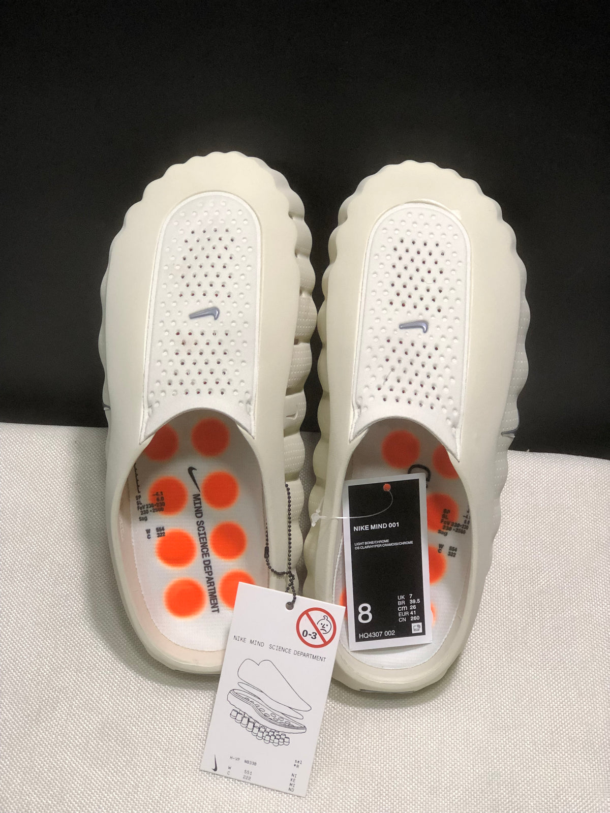 Top-down view showing perforated uppers, textured footbeds, product tags, and the photographed size label.