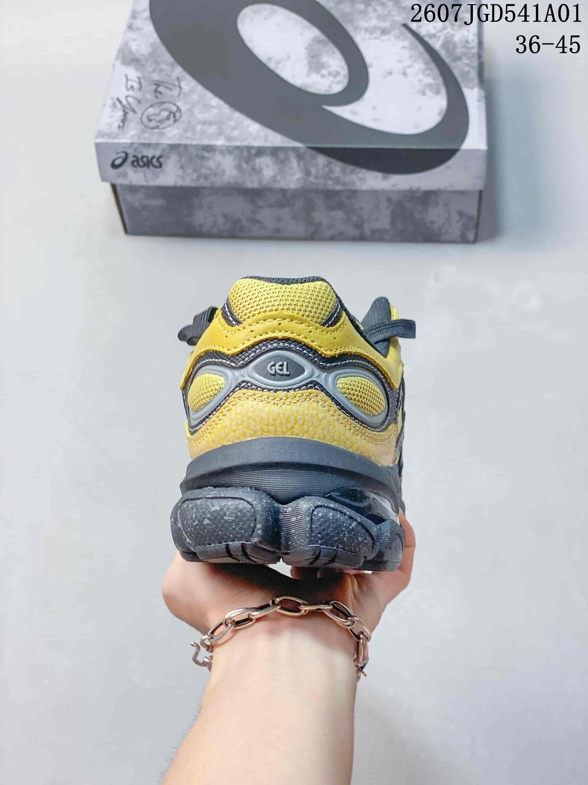 Rear view showing the heel and outsole of the yellow and charcoal sneaker