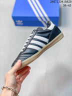 Side profile showing the black upper, white stripes, white heel detail, and gum outsole.
