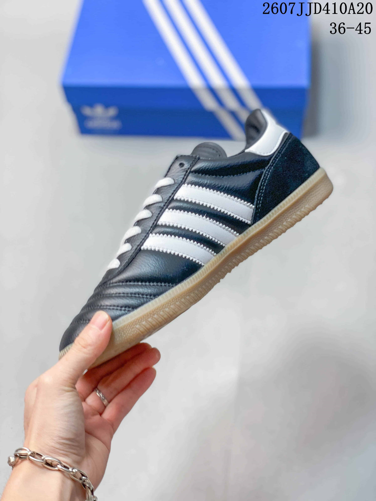 Side profile showing the black upper, white stripes, white heel detail, and gum outsole.