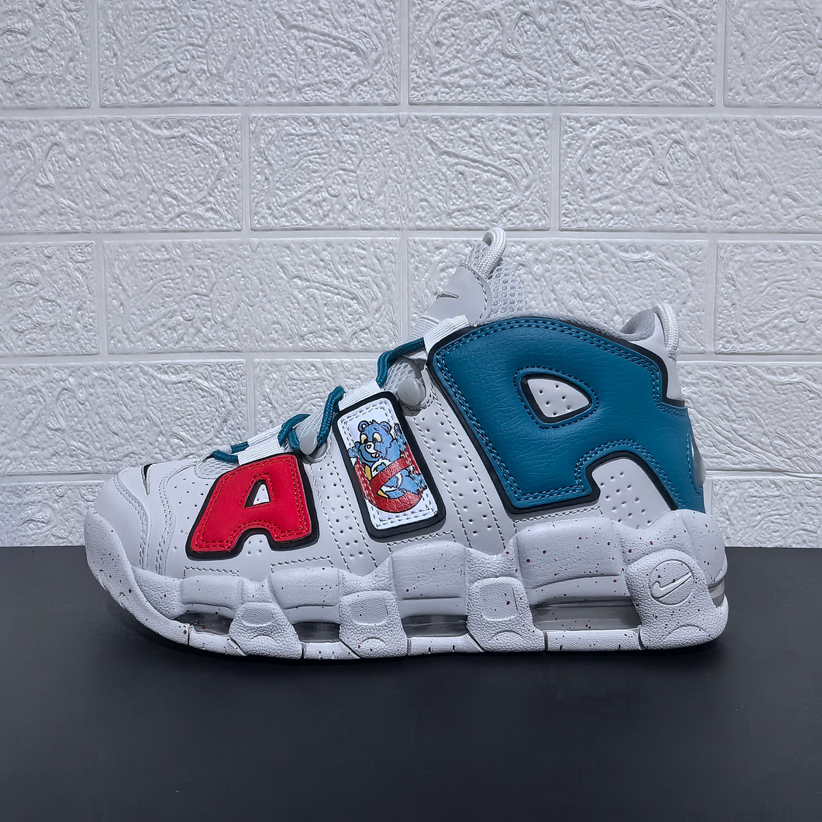 Side profile highlighting the blue heel panel and red letter accent