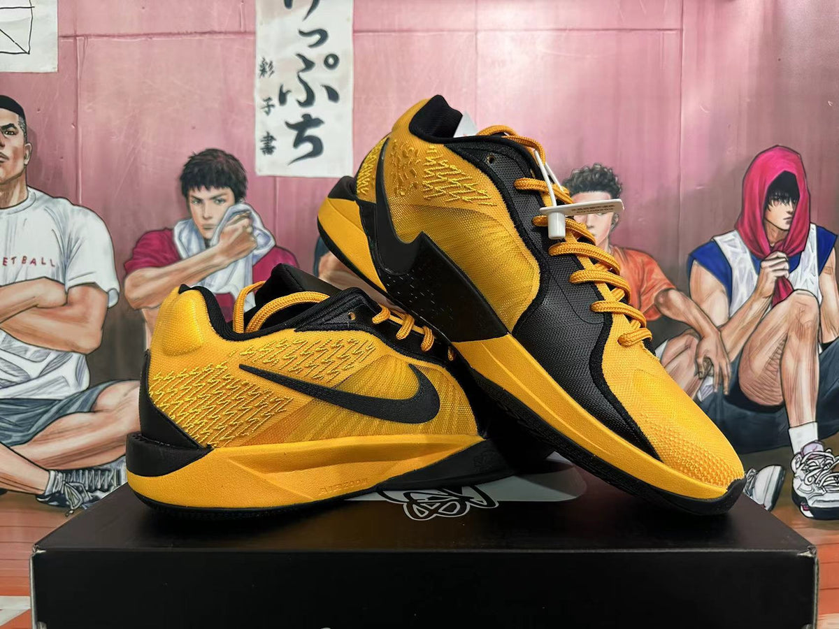 Pair of black and yellow Nike basketball shoes shown from the side