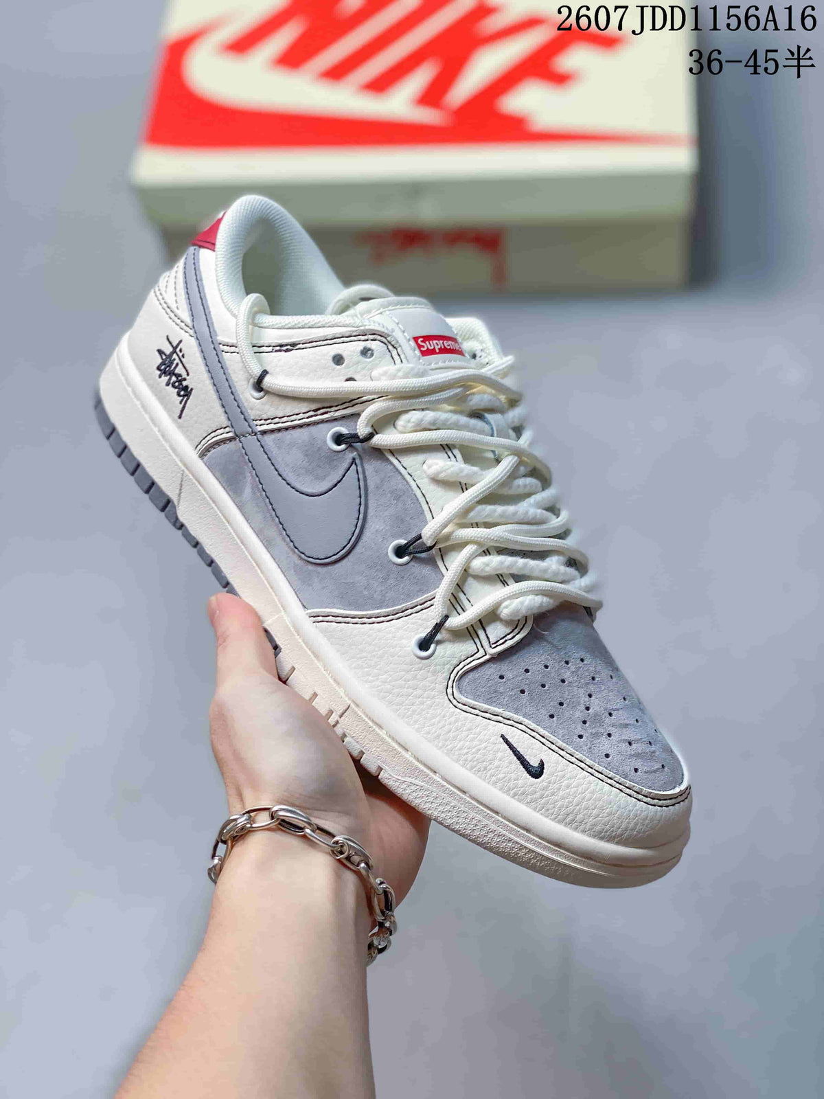 Close side view of an off-white and grey sneaker showing the Swoosh, red tongue label, perforated toe box and graphic heel detail.