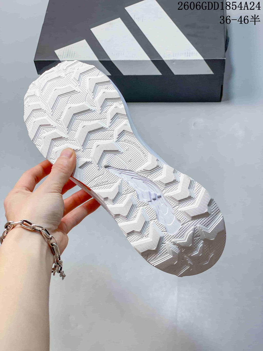 Close-up of the deeply patterned outsole on a white trail-running shoe