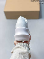 Rear view of the white sneaker showing the textured heel upper and thick sculpted sole.