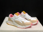 Front three-quarter product view highlighting the white and beige upper, pink toe accents and sculpted sole.