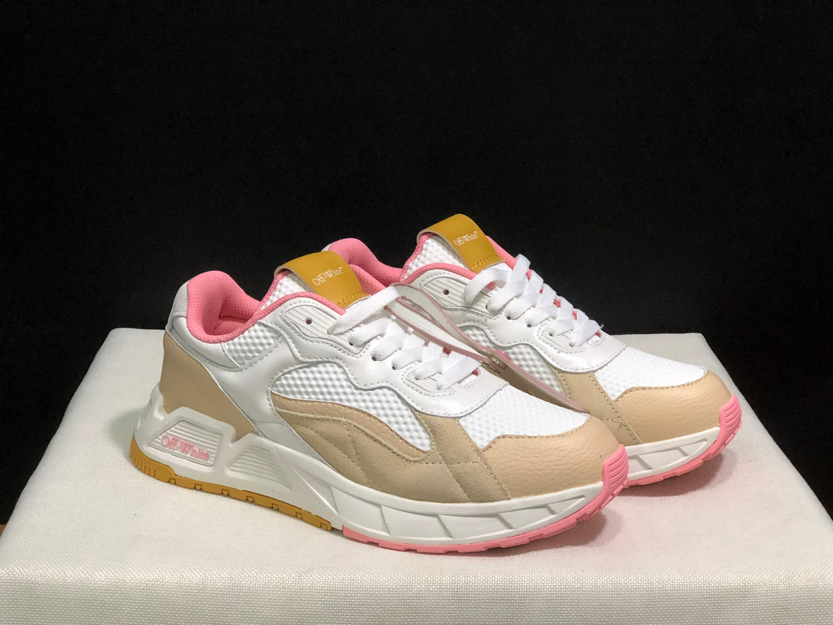 Front three-quarter product view highlighting the white and beige upper, pink toe accents and sculpted sole.