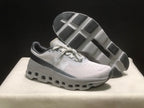 Angled view showing one shoe above the other with the textured outsole and geometric tread sections visible.