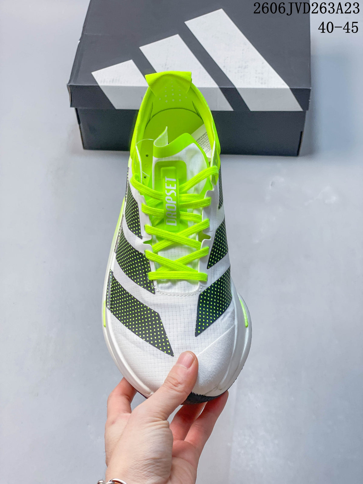Top view showing neon-yellow laces, white upper and dark patterned stripes.