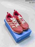 Pair of red and silver Adidas sneakers displayed on a blue shoebox, showing the low-top shape, lace-up closure, and layered upper.