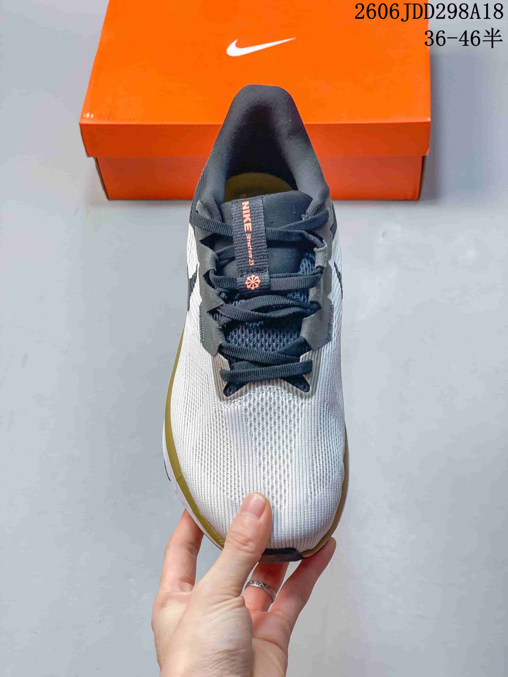 Top view of the sneaker showing the white textured toe, dark laces and padded tongue.