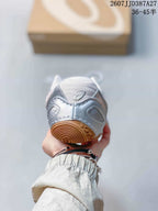 Rear view of the silver sneaker showing the padded collar, heel details, and gum outsole.