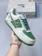 Angled side view showing the white and green sneaker, AIR heel branding, patterned side accent, and green outsole.