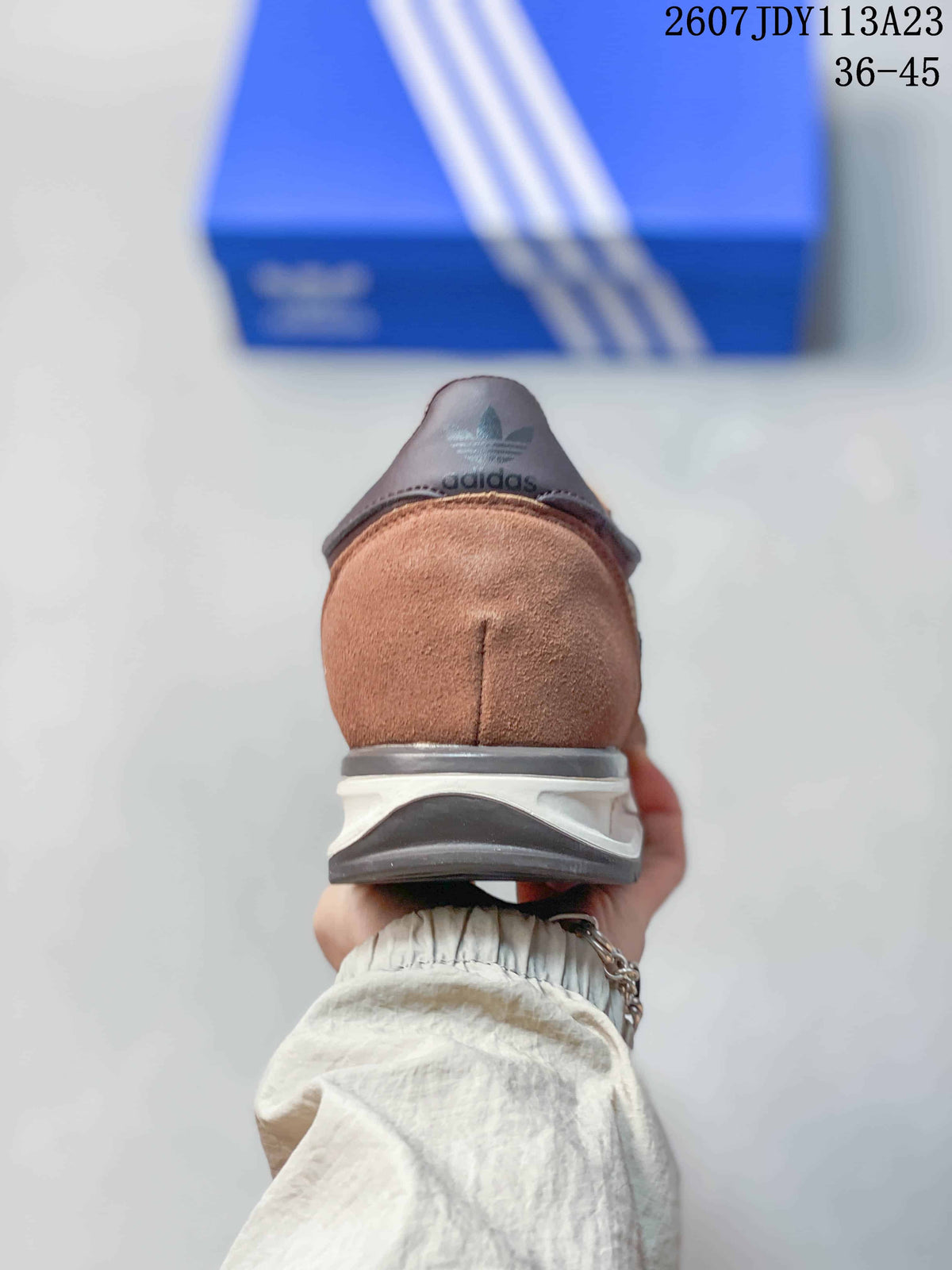 Rear view of the brown adidas sneaker showing the heel, layered white midsole, dark outsole, and heel branding.