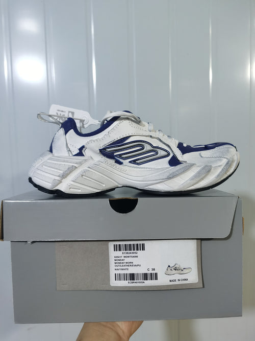 Side view of the navy and white sneaker resting on its box; the box label shows style code WDWTS4090, color NAVY/WHITE, and size C 38.