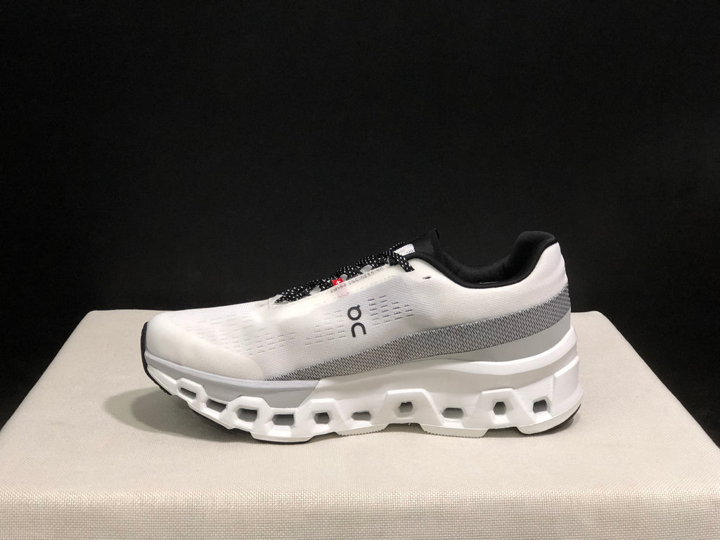 Side view of a white and silver On Cloudmonster 2 shoe