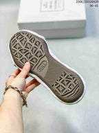 Bottom view of an MMY sneaker showing the patterned brown rubber outsole and textured tread.