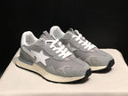 Front three-quarter view of the pair showing grey textured overlays, white laces, white star emblems, and cream midsoles.