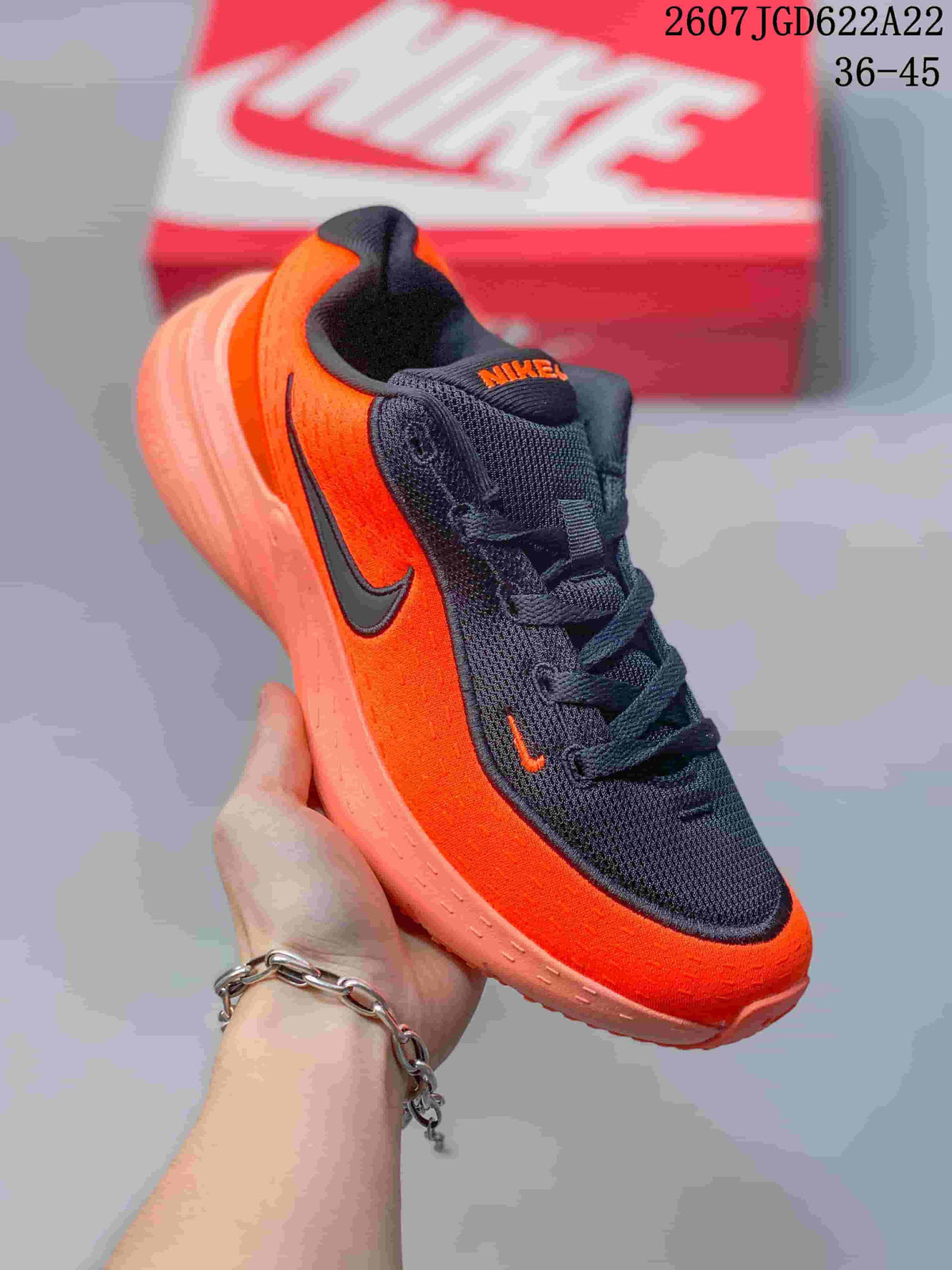 Angled side view showing the orange and black Nike Uplift SC upper and contrasting sole.