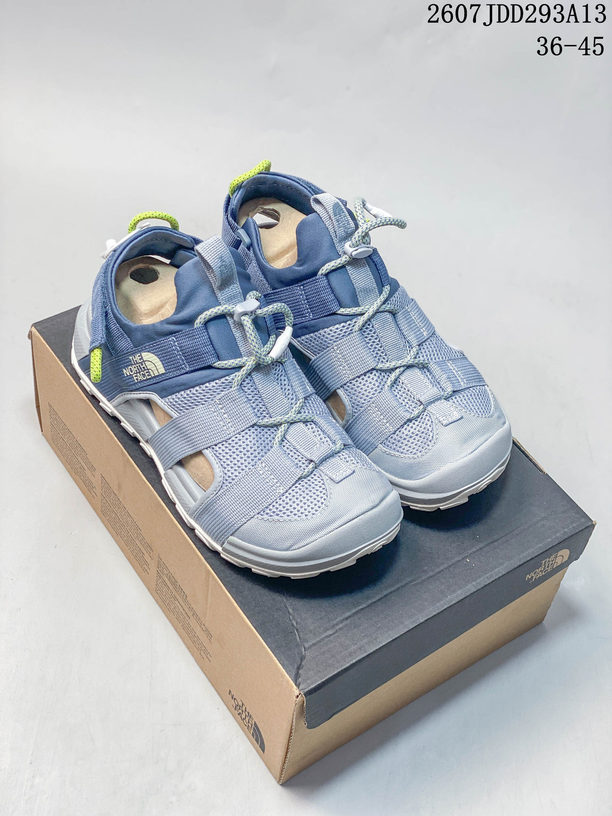 Pair of blue-gray The North Face outdoor sandals displayed on a branded shoe box.