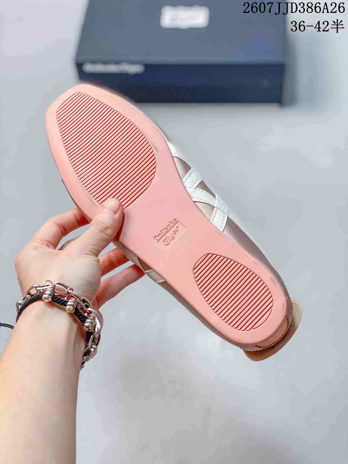 Underside of a pink shoe showing the flat outsole and textured tread zones, with the shoe box in the background.