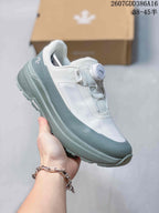 Pale green and white DESCENTE low-top sneaker shown from the side, featuring a BOA dial closure, layered upper panels and a lugged outsole; source overlay shows product code 2607GDD386A16 and size notation 38–45 with half sizes.