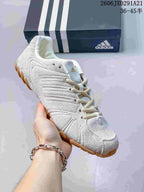 White adidas Ghost Sprint sneaker shown from a front-side angle with a gum-colored outsole.