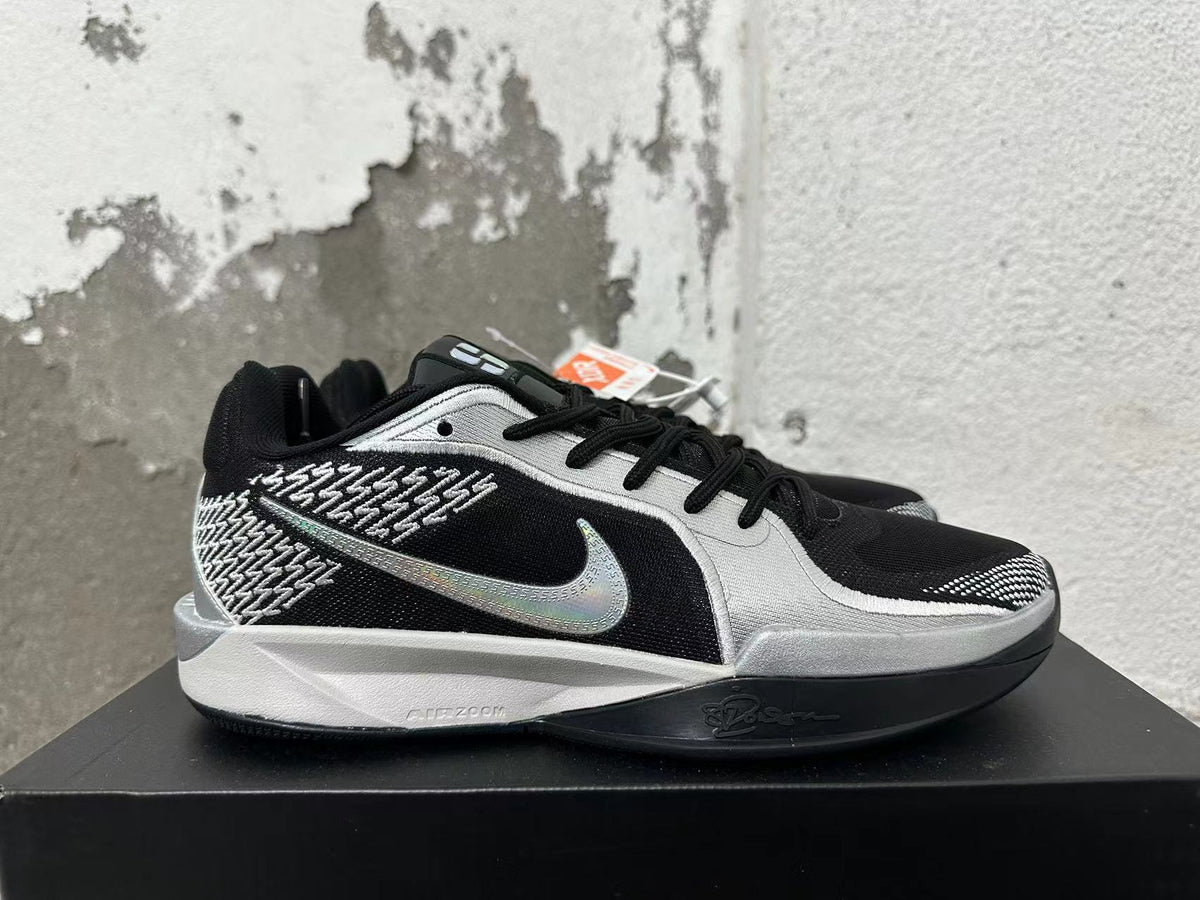 Side view showing the Swoosh, silver accents, and patterned black upper.