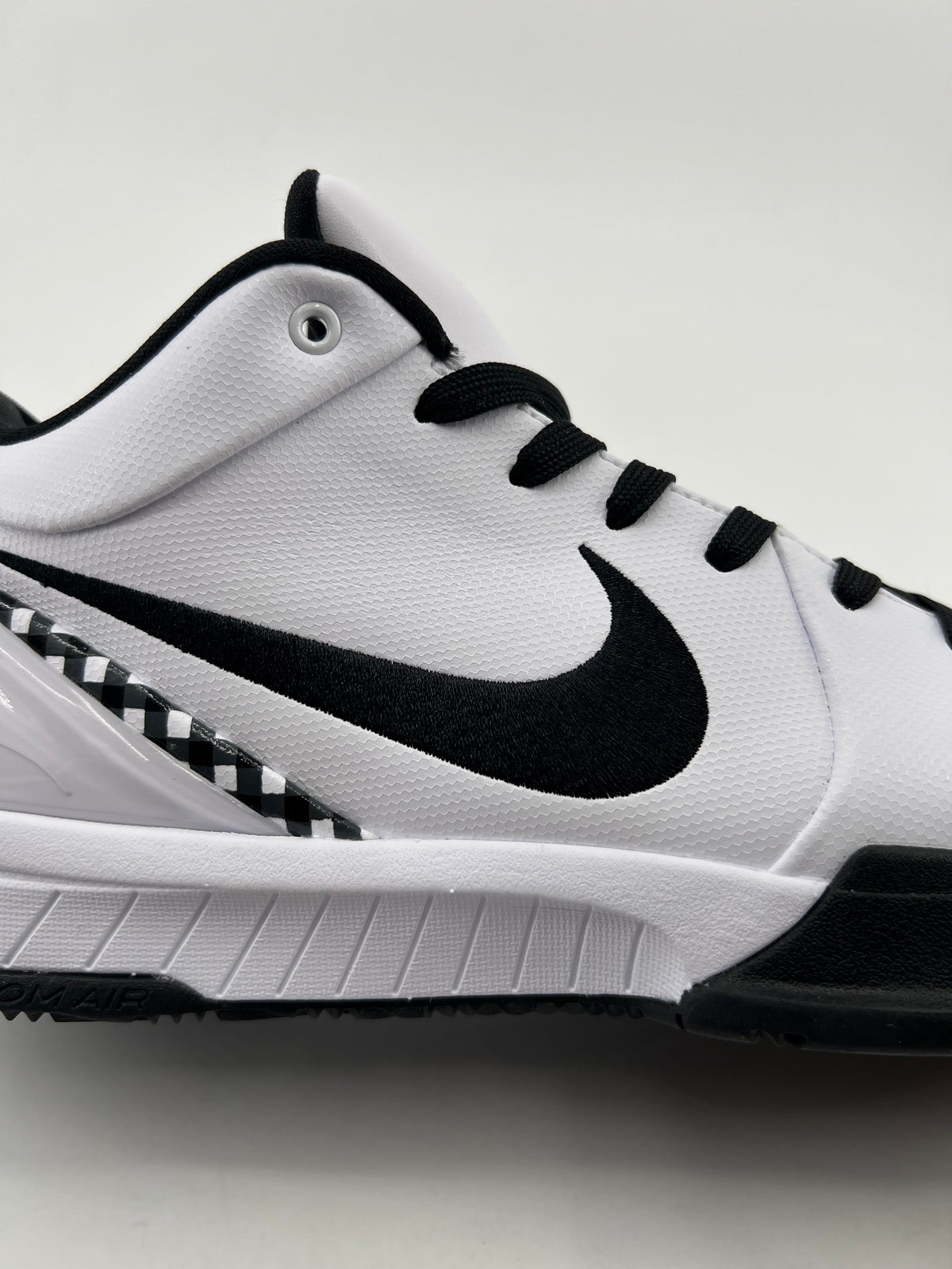 Side view of the white basketball shoe with black Swoosh and sole accents