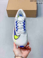 Top view of a white Nike running shoe with blue lace loops, white laces and a multicolor Swoosh.