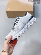Side profile of the white low-top sneaker showing the knit-style upper, On side branding, laces, and segmented sole.