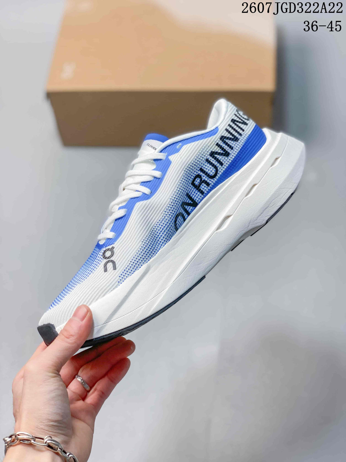 Side profile of the white and blue running shoe showing the large On Run graphic and raised white midsole.