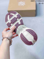 Underside of an On sneaker showing the segmented off-white and burgundy outsole pattern.